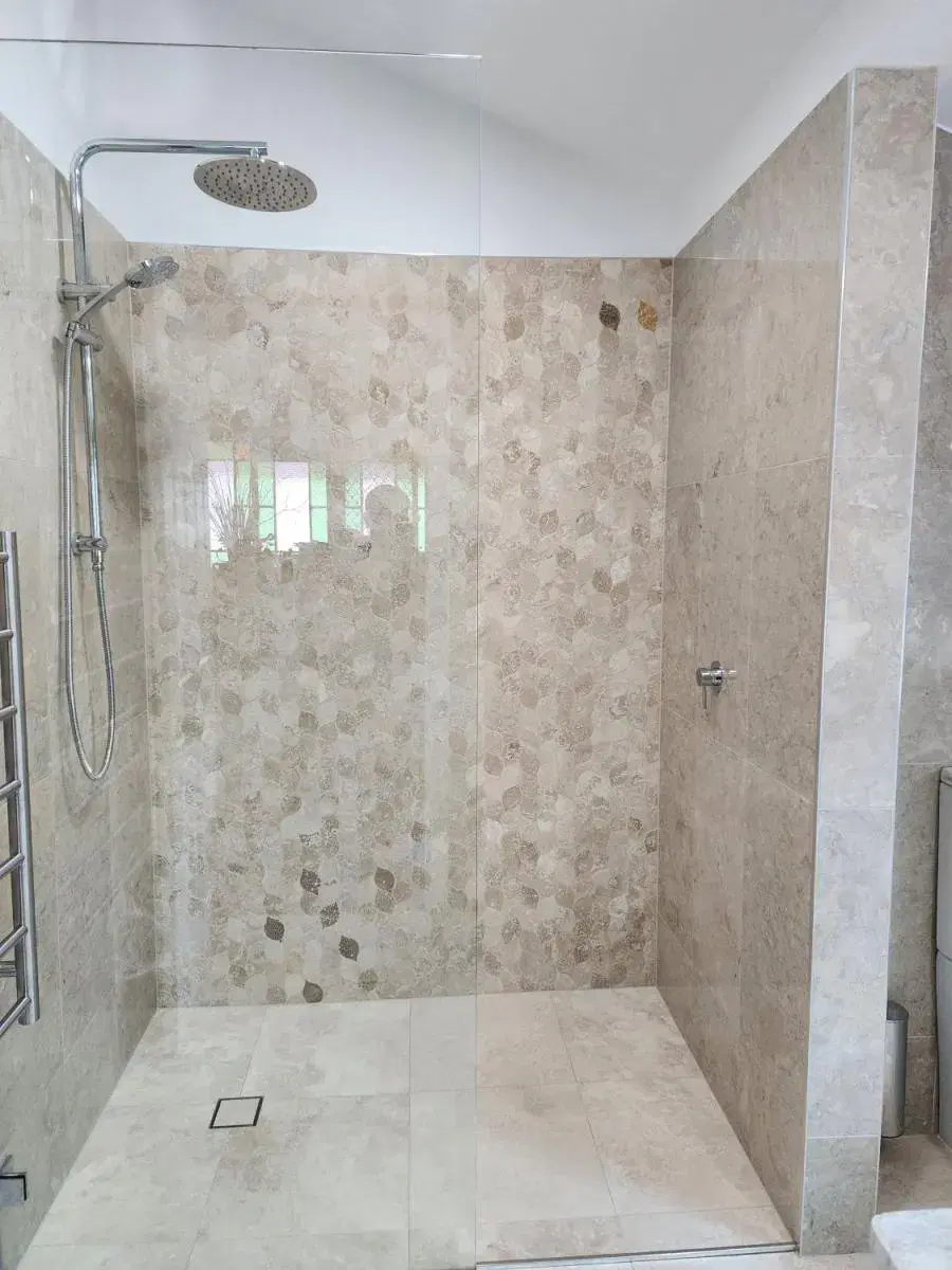Walk-in shower with feature stone tiling in North Ipswich