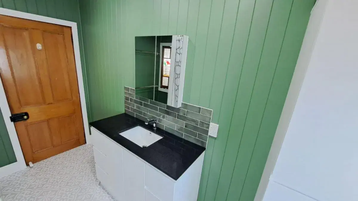 Renovated Queenslander wet area with painted timber wall linings and an original timber door
