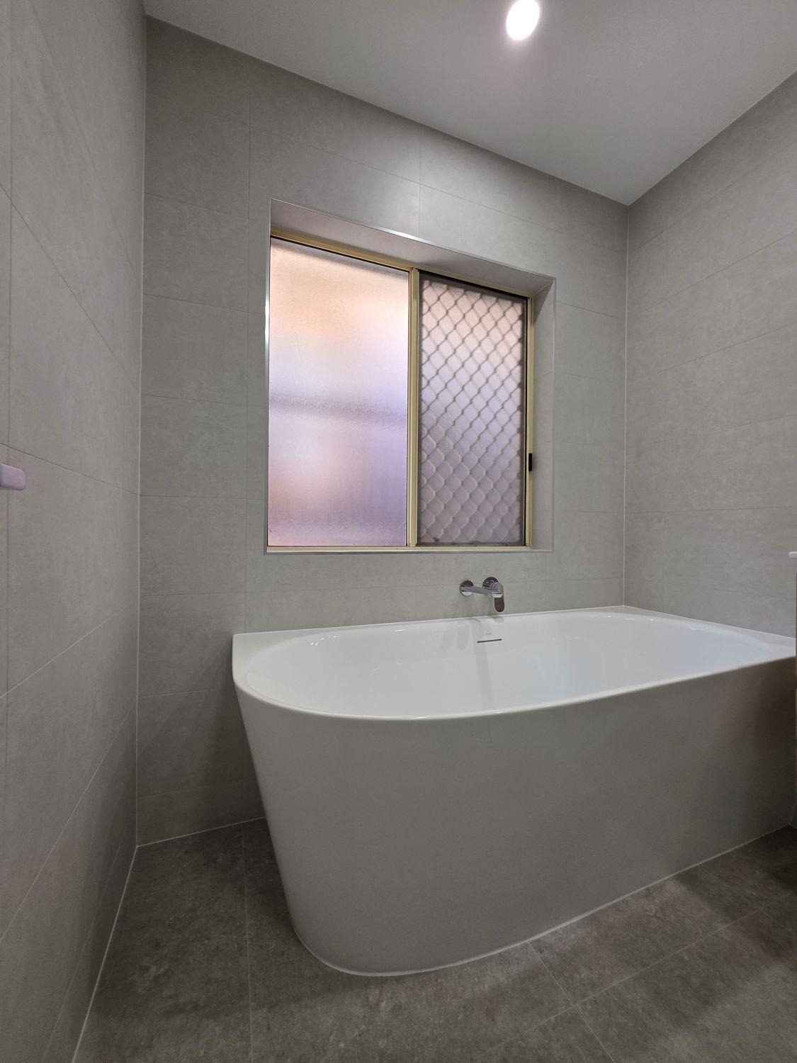 New freestanding bath below the existing window in the Bellbowrie bathroom