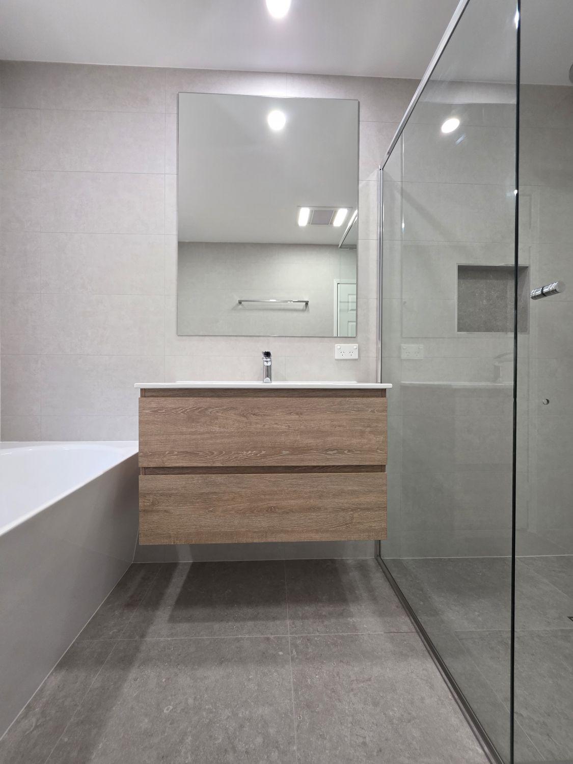 Floating timber-look vanity and large mirror in the completed Bellbowrie bathroom