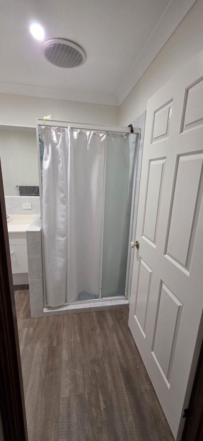 Bellbowrie bathroom before renovation with an enclosed shower beside the doorway