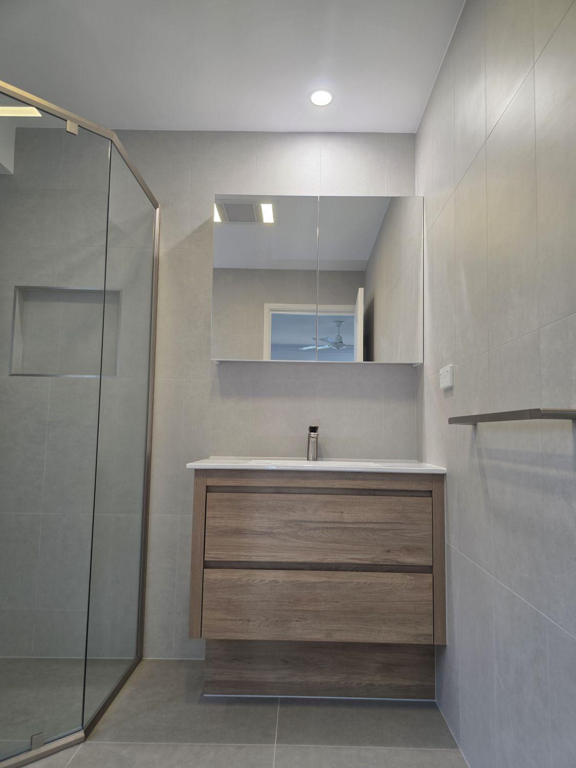 Timber-look vanity and mirrored storage in the North Lakes ensuite