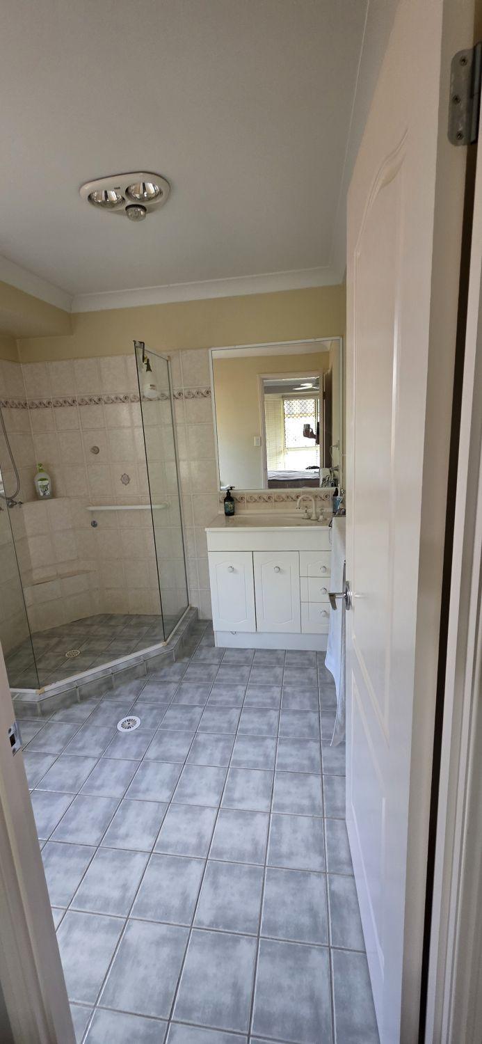 North Lakes ensuite before renovation with raised angled shower and white vanity