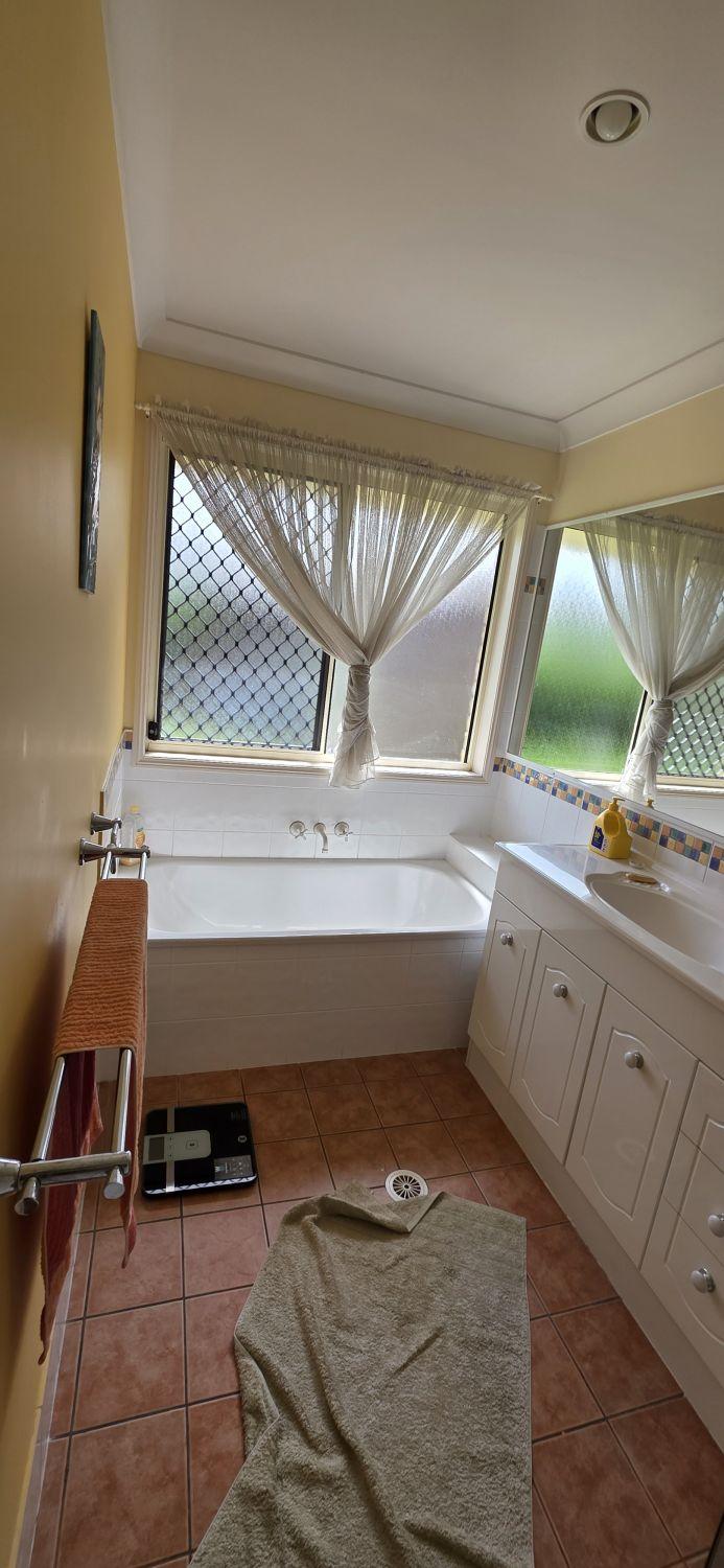 North Lakes main bathroom before renovation with built-in bath and long white vanity