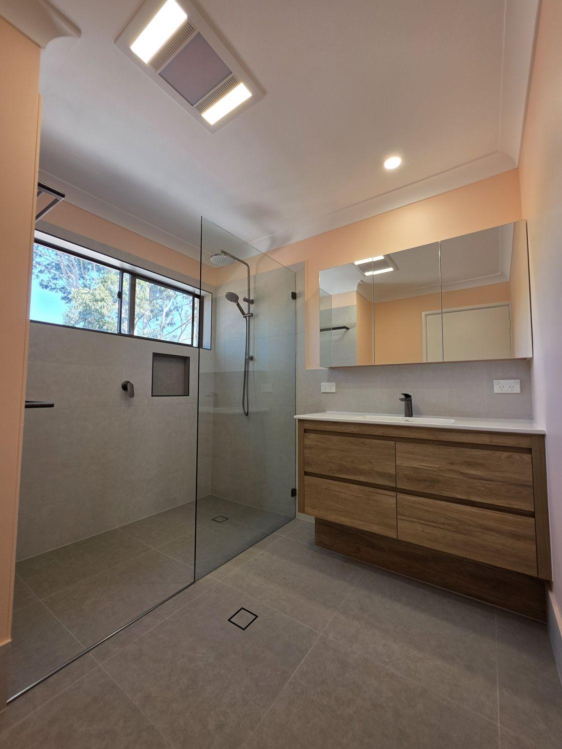 Completed Tarragindi bathroom with open glass shower and wide timber-look vanity
