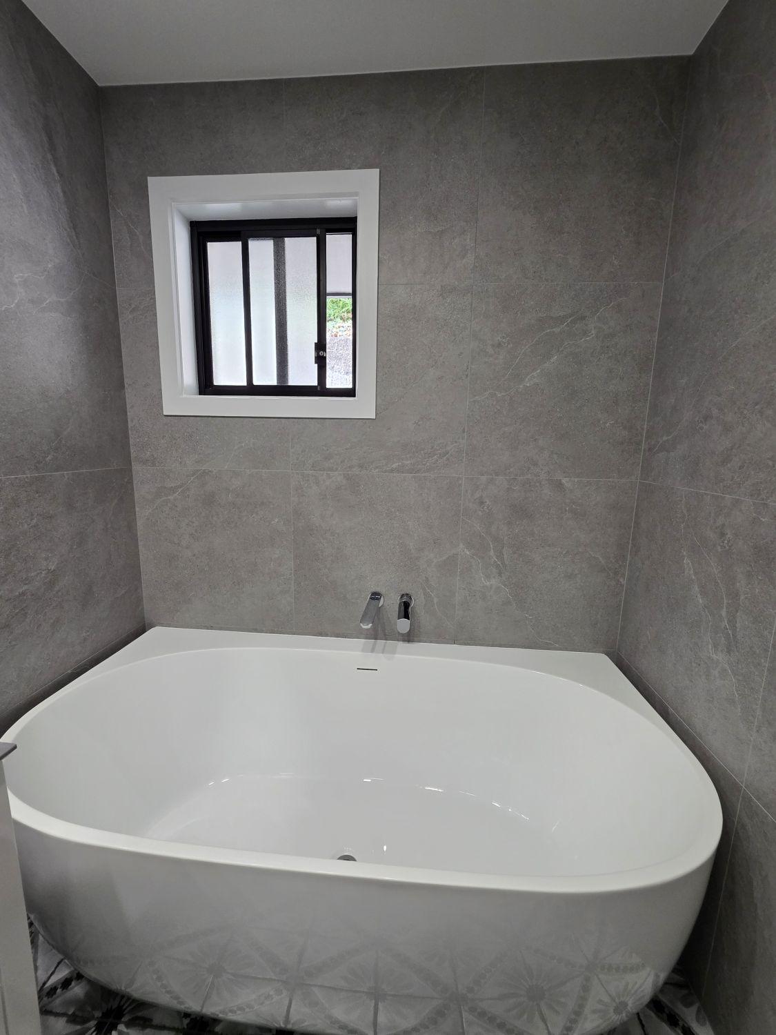 Freestanding bath below the window in the Augustine Heights bathroom