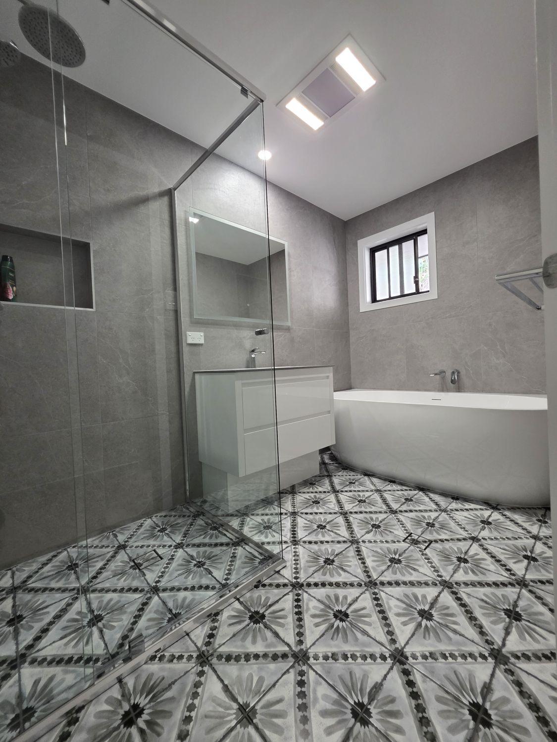 Augustine Heights bathroom entrance after renovation with open glass shower, floating vanity and freestanding bath