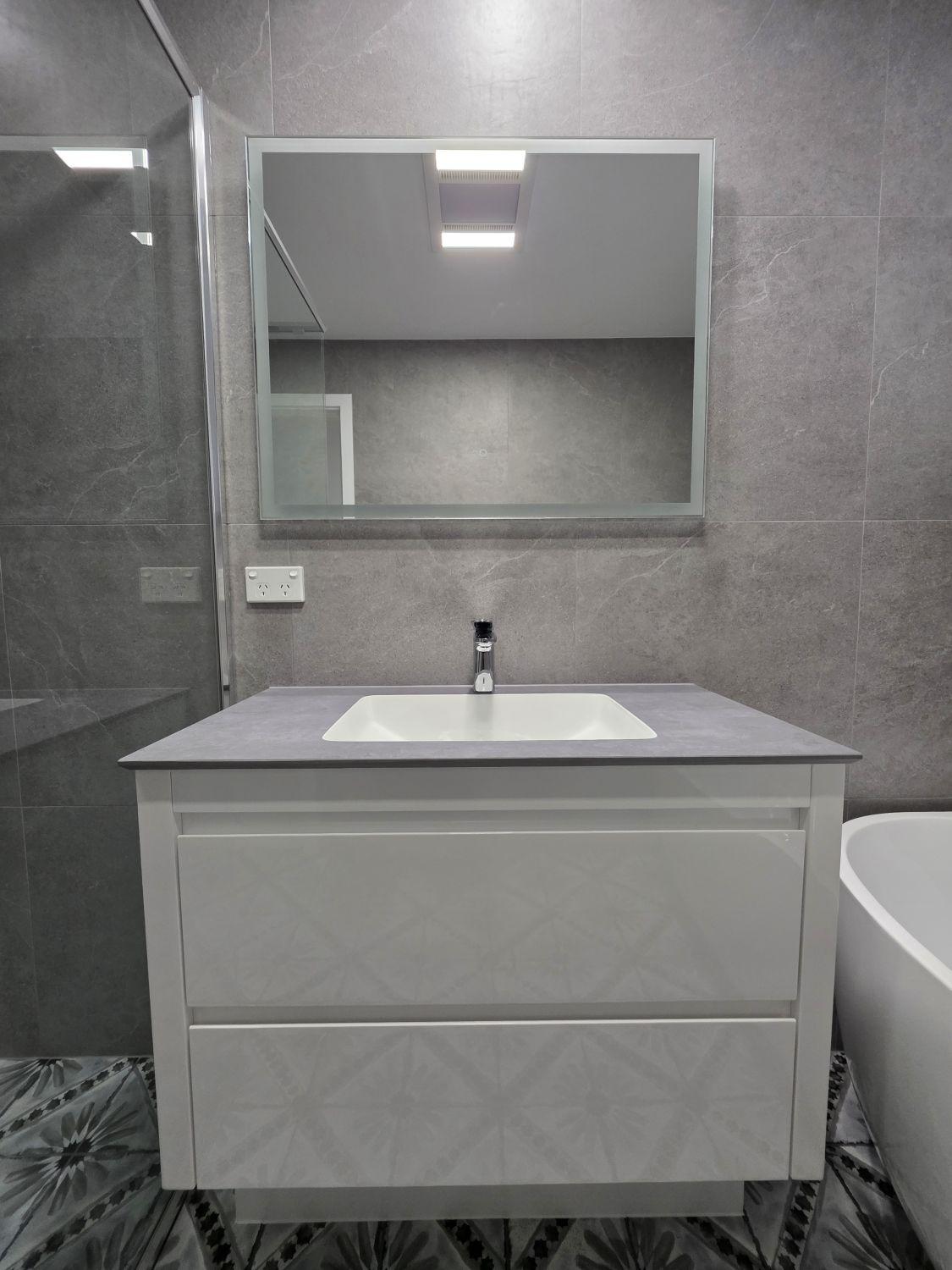 Floating vanity and broad mirror in the completed Augustine Heights bathroom