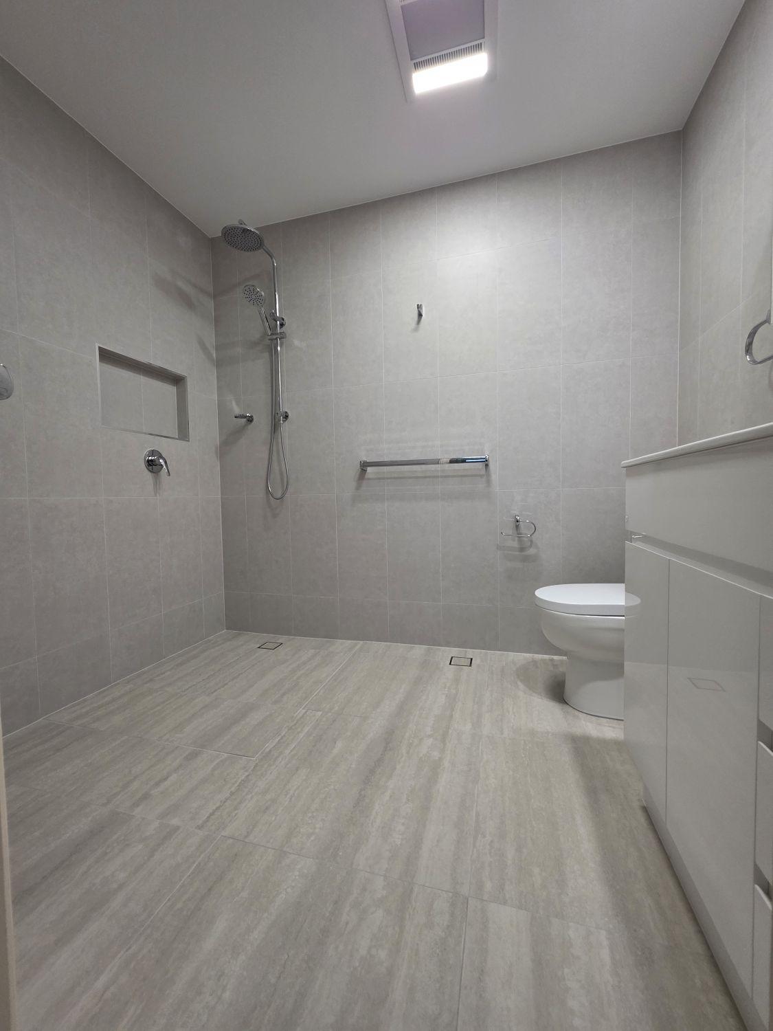Bardon bathroom after renovation with continuous level floor and open shower