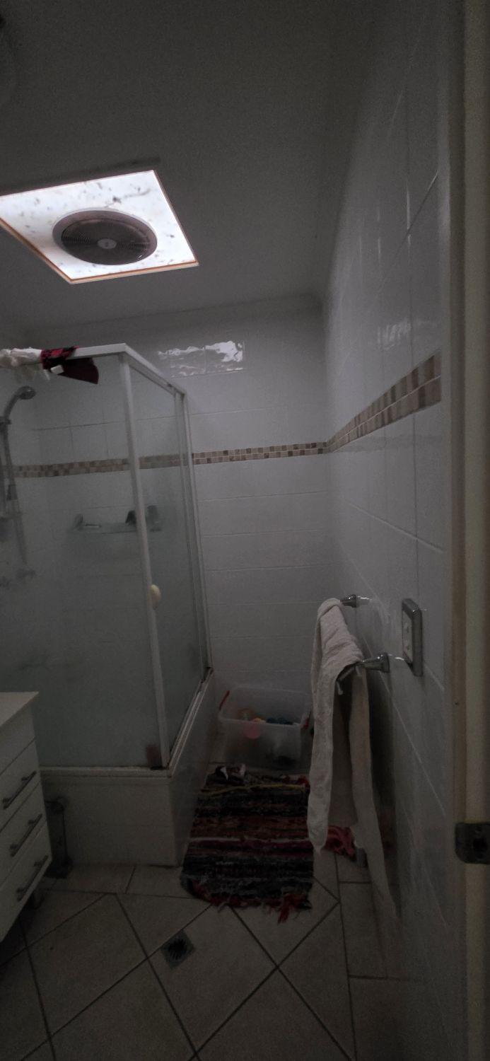 Raised enclosed shower in the Holland Park bathroom before renovation