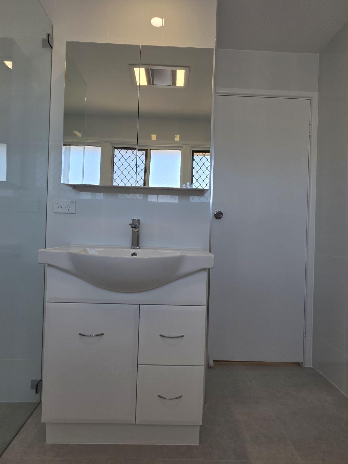 Floating white vanity and mirrored cabinet in the completed Inala bathroom