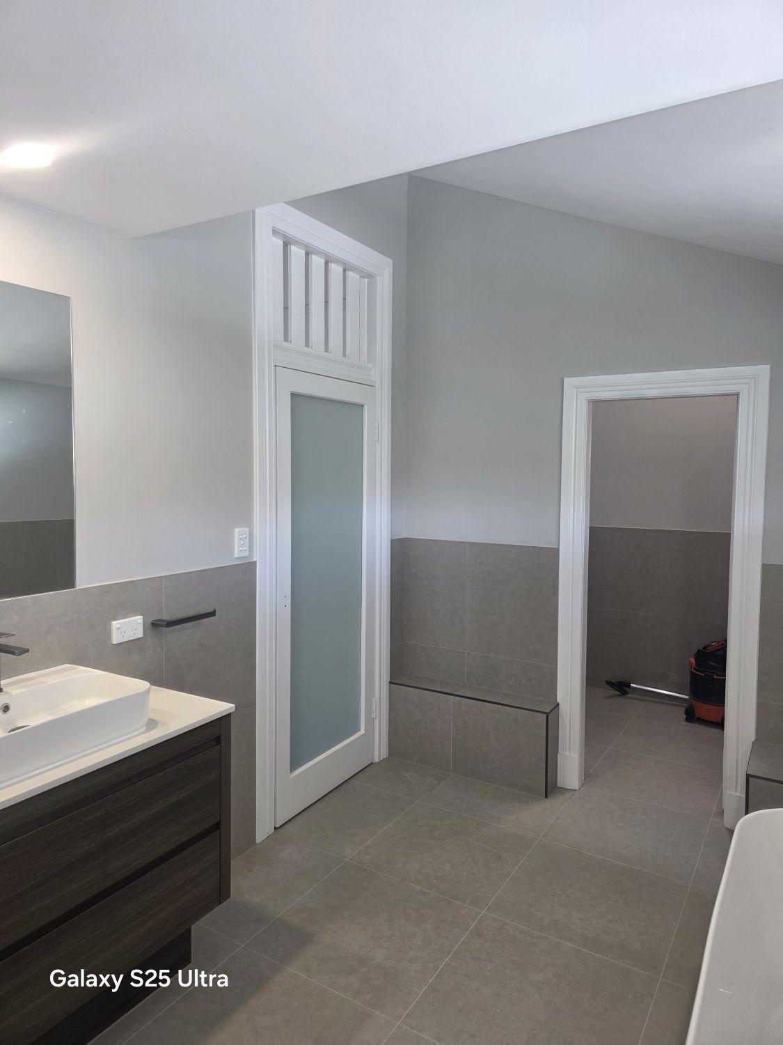 Kalinga ensuite after renovation with floating vanity, bath and tiled circulation space