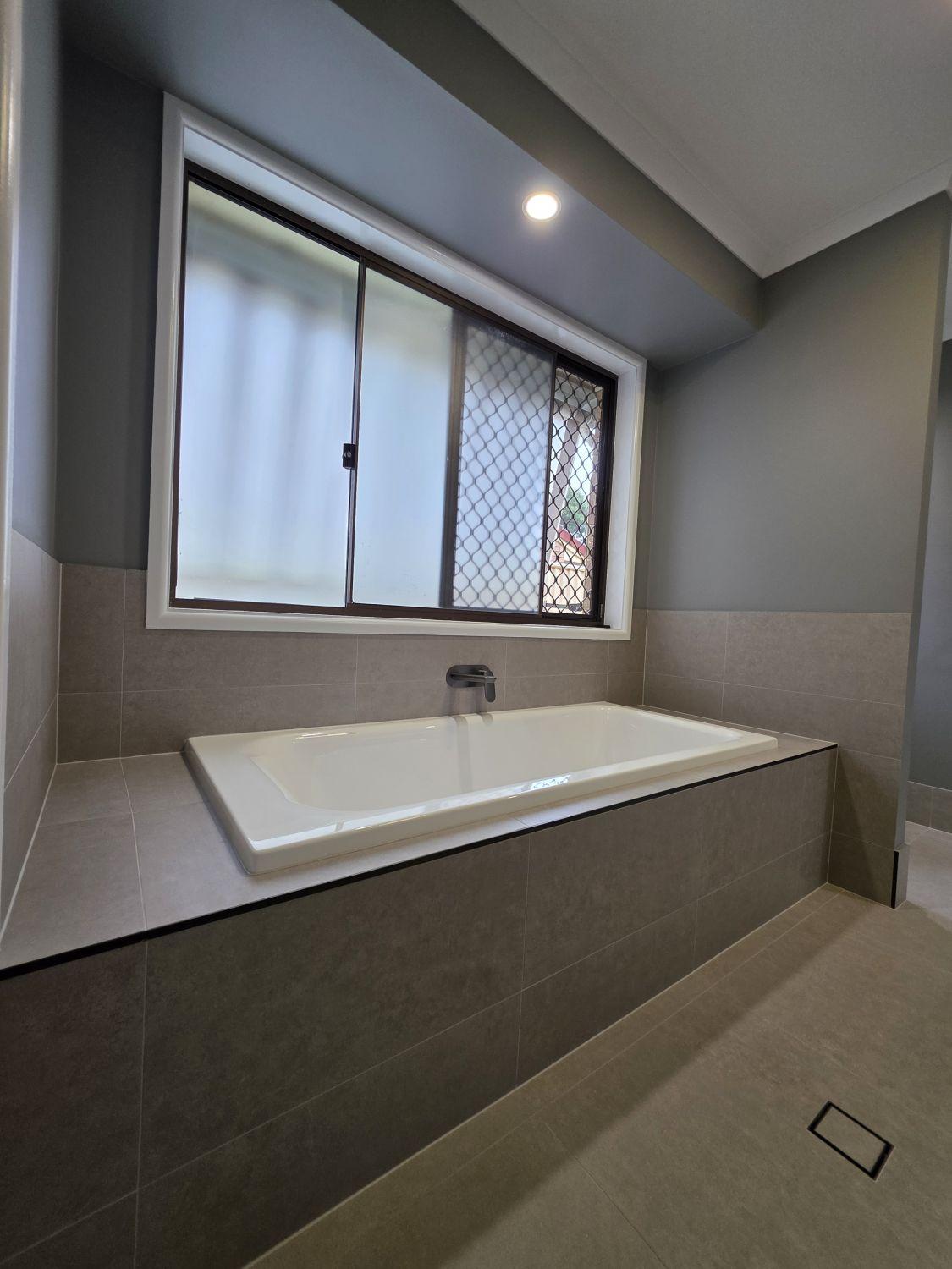 Tiled bath below the window in the second Karana Downs bathroom