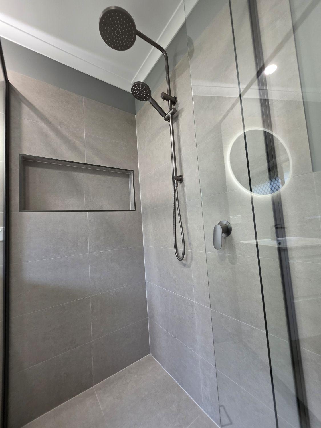 Black-framed glass shower with dual fittings and niche in Karana Downs
