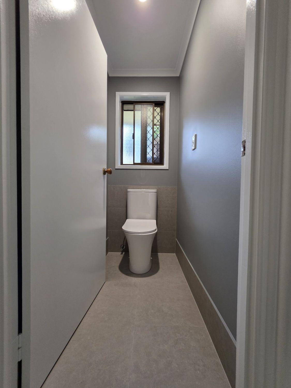 Separate Karana Downs toilet after renovation with grey tile and paint