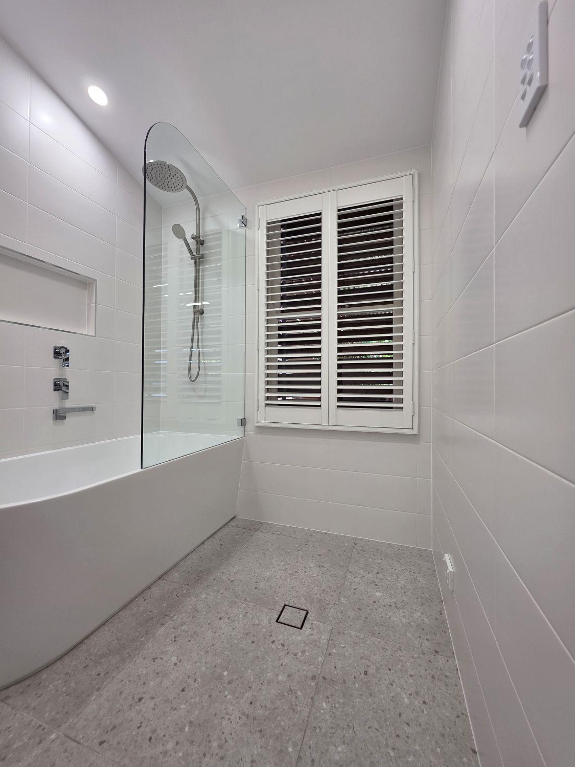 Bright tiled bath area beside the retained shuttered window in Stones Corner