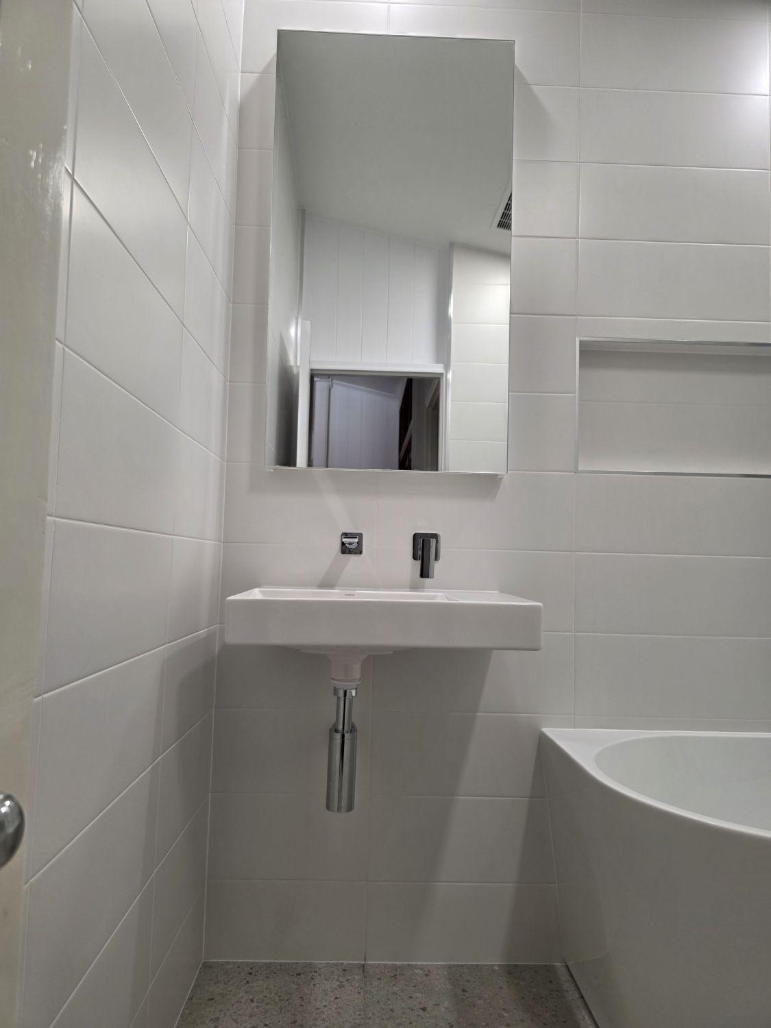 Wall-hung basin and mirror in the completed Stones Corner bathroom