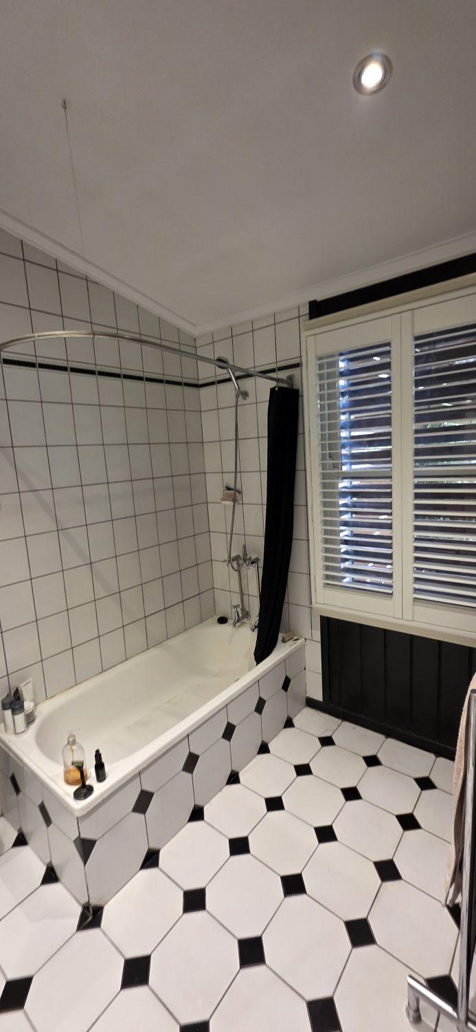 Original shower curtain and built-in bath in the Stones Corner bathroom