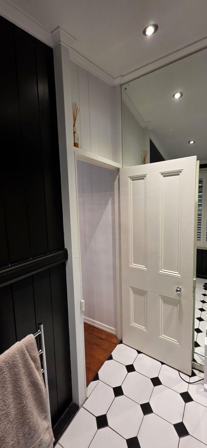 Original dark and white finishes near the Stones Corner bathroom doorway
