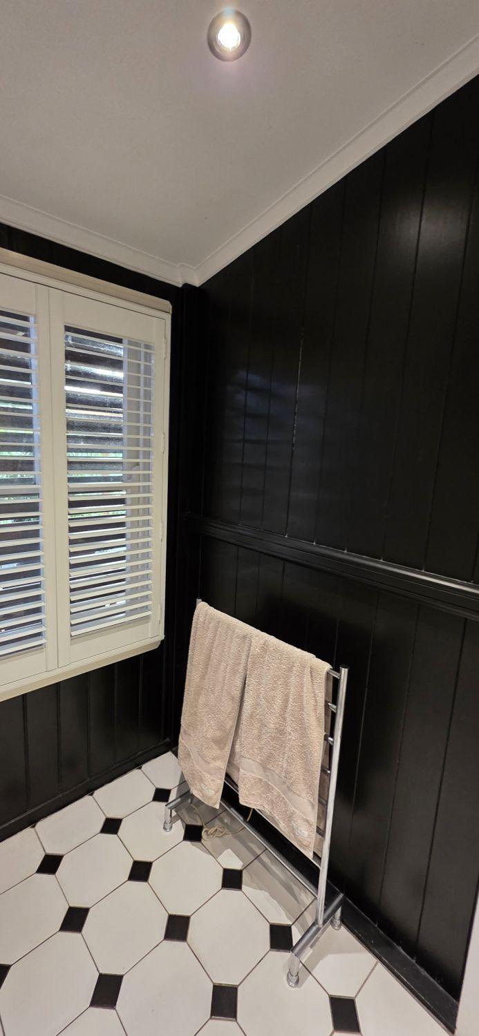 Dark panelled wall beside the window in the original Stones Corner bathroom