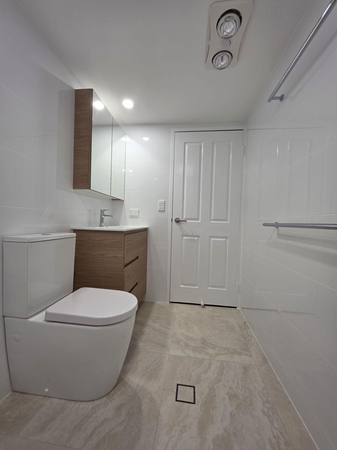 Renovated Taringa bathroom with streamlined toilet and timber-look vanity