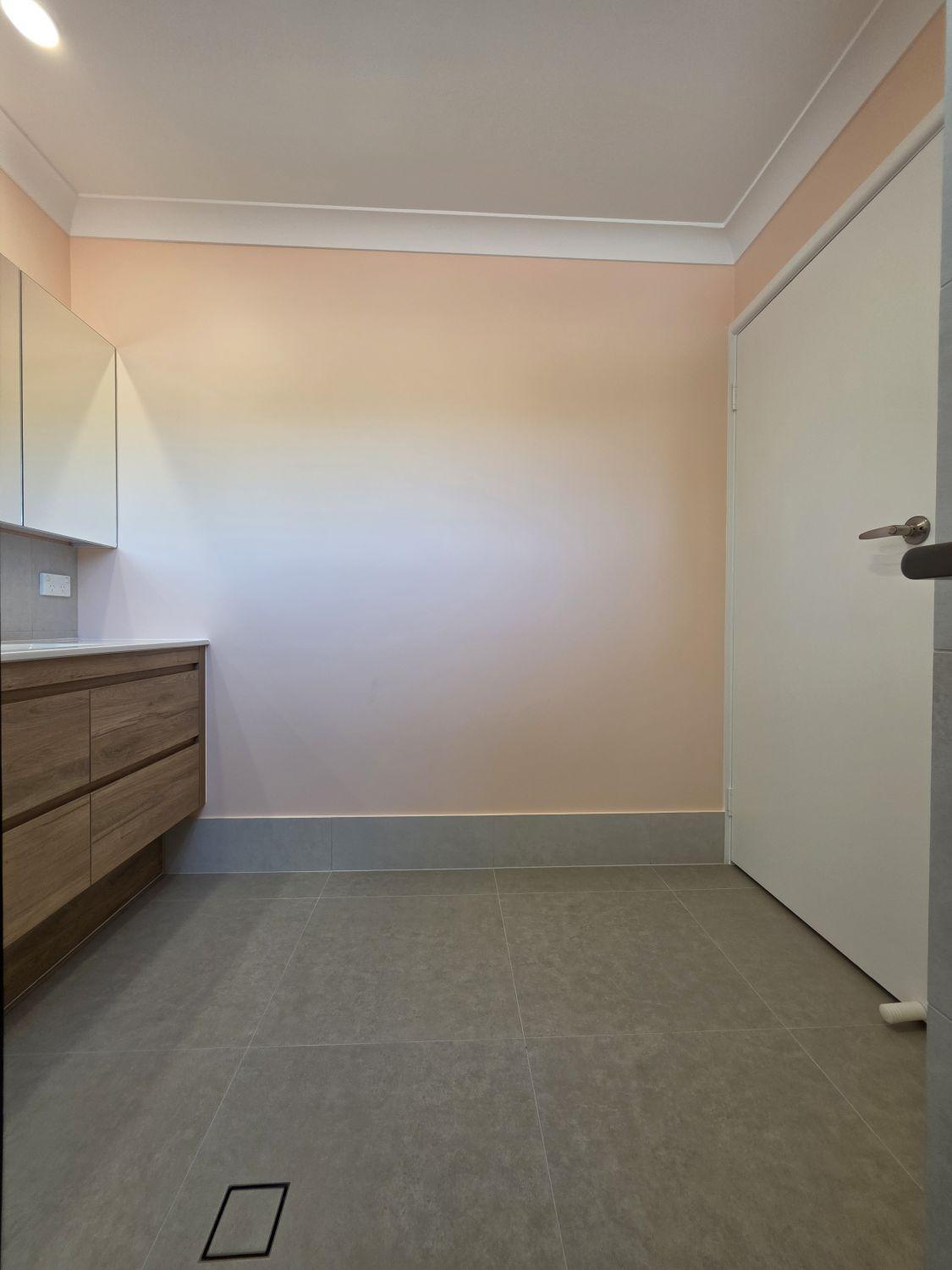 Open tiled floor area beside the vanity in the completed Tarragindi bathroom