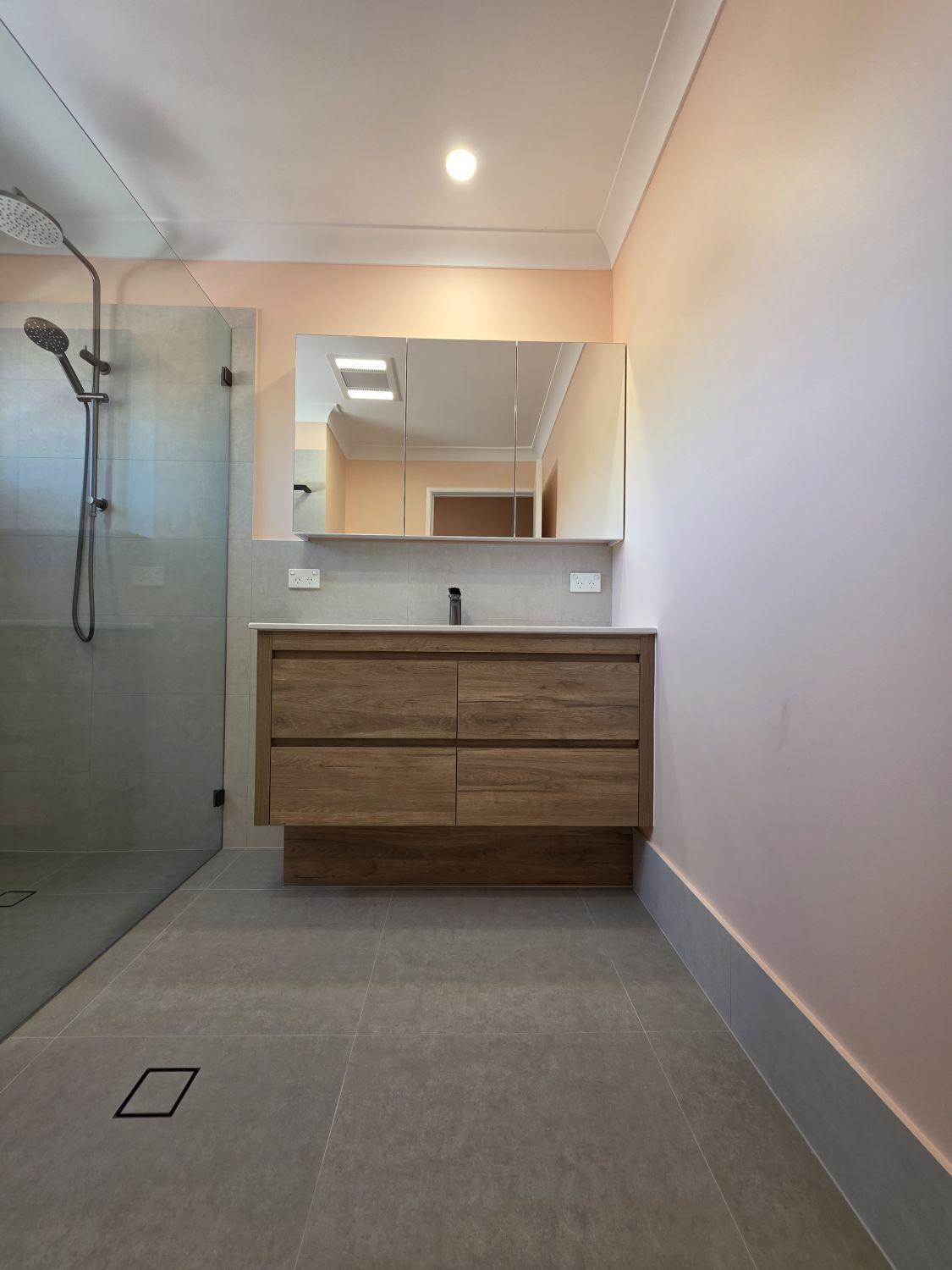 Wide timber-look vanity and mirrored cabinet in the Tarragindi bathroom