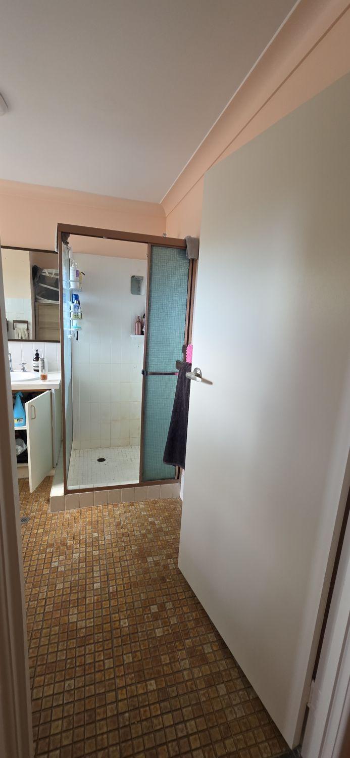 Tarragindi bathroom entrance before renovation with framed shower ahead